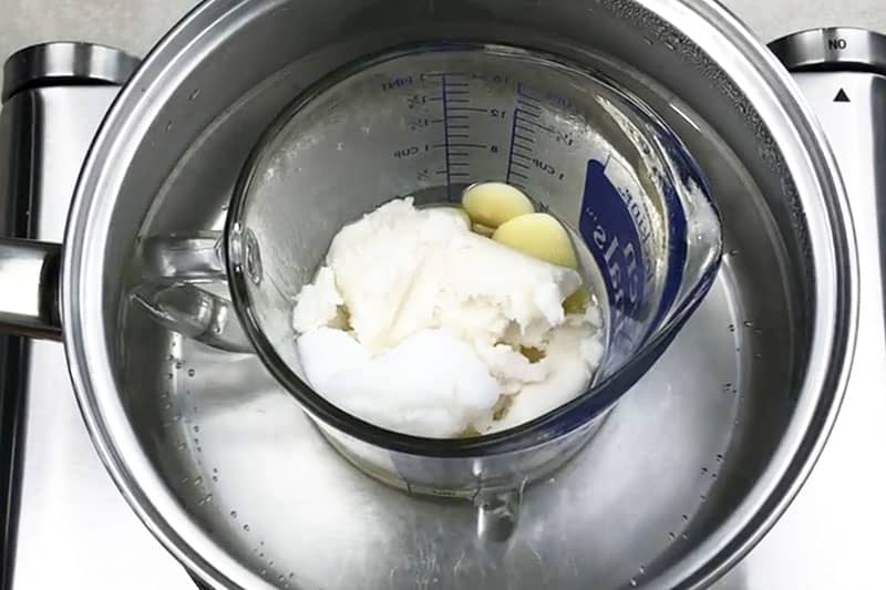 adding body butter ingredients into pan and sitting on stove