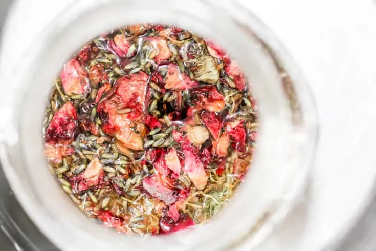 How to Quickly Make Herbal Infused Carrier Oils: Rose, Lavender and Calendula herbs being infused in a jar of carrier oil.