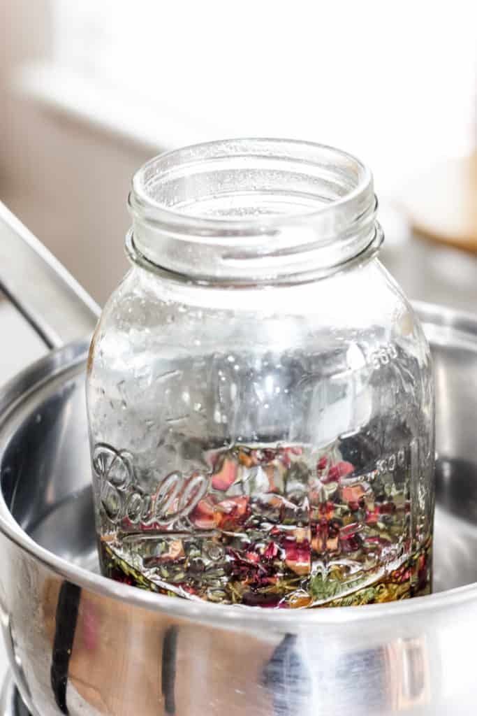 How to Quickly Make Herbal Infused Carrier Oils: Rose, Lavender and Calendula herbs being infused in a jar of carrier oil.