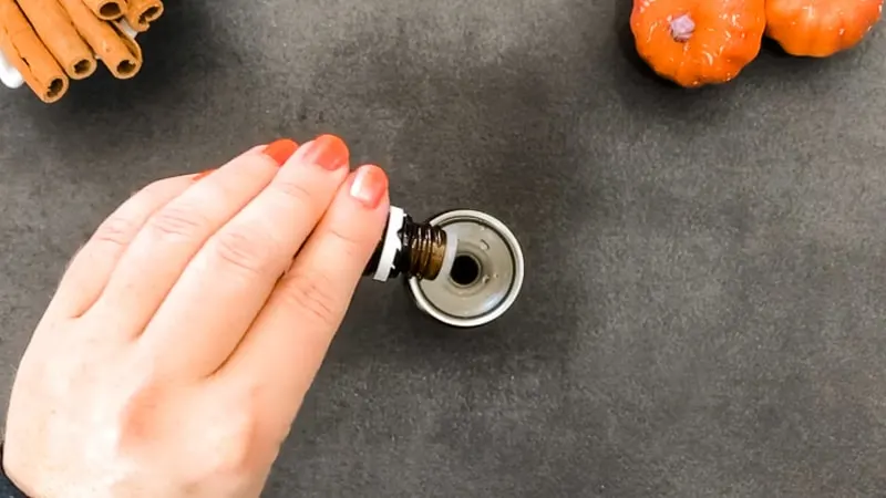 Pour essential oils into glass bottle of diy pumpkin spice essential oil room spray