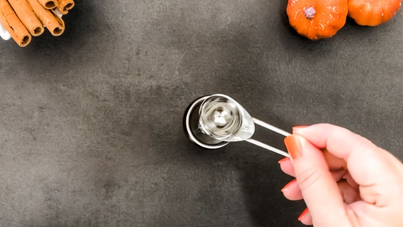 Pour vodka into glass bottle of diy pumpkin spice essential oil room spray