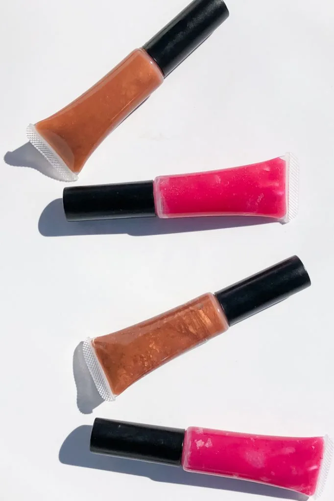 4 tubes of homemade lip gloss in bronze and bright pink