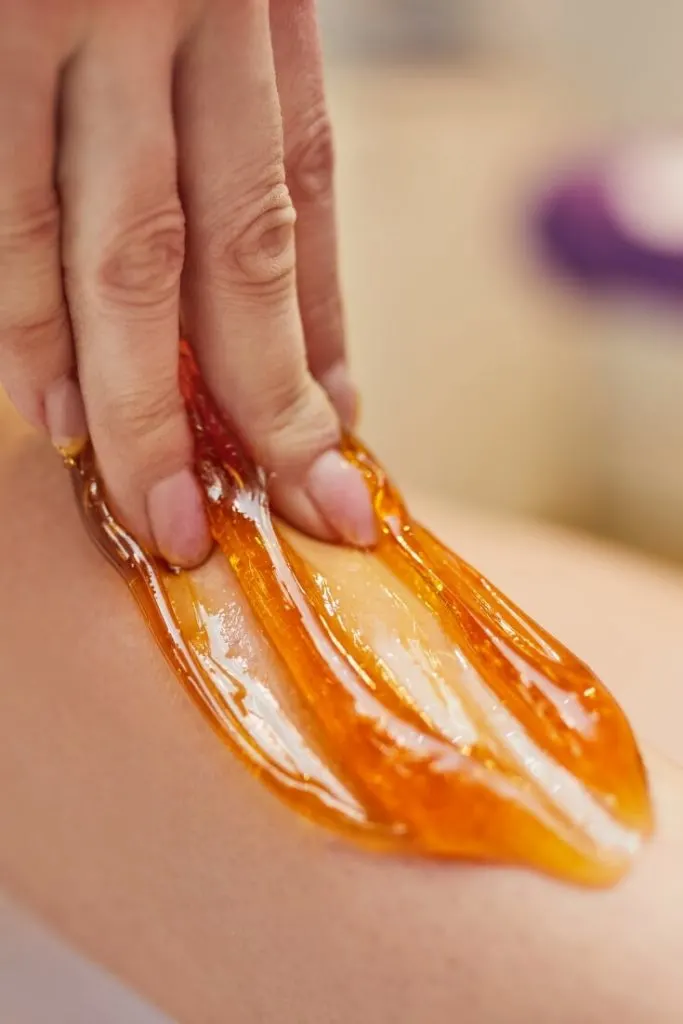 applying sugaring wax to leg